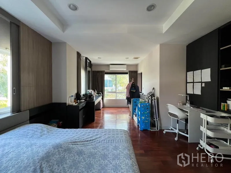 Detached House for rent or sale in Saphan Sung, Bangkok - Spacious master bedroom with wood flooring, desk and wide windows.