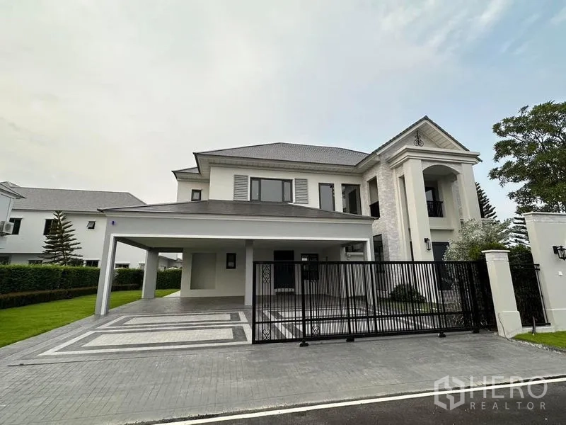 Detached House for sale in Lat Krabang, Bangkok - Front elevation of the detached house with gated driveway and wide covered parking.