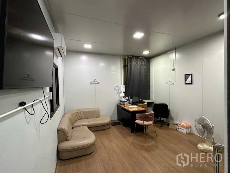Factory for rent in Khlong Luang, Pathum Thani - Office room with desk, sofa, air conditioning and wood-style flooring inside the factory.