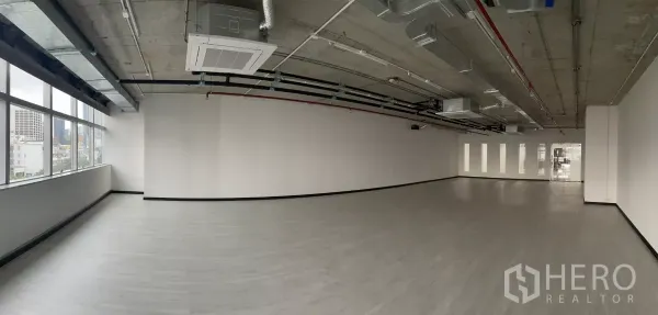 Office Space for rent in Bang Rak, Bangkok - Panoramic view of open-plan office featuring long row of windows and cassette air-conditioning units.