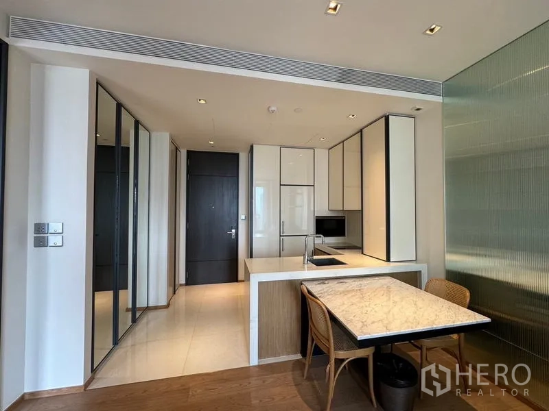 Condominium for rent in Khlong Toei, Bangkok - Fully fitted kitchen with island sink, stone countertops and a marble dining table.
