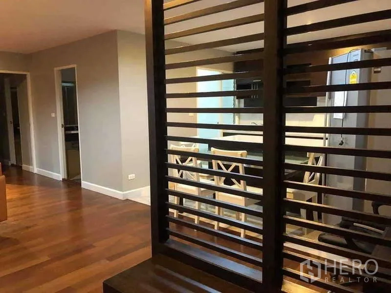 Condominium for sale in Yan Nawa, Bangkok - Open-plan living area with a wooden slatted divider looking toward the dining and kitchen.