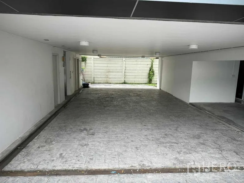 Home Office for rent or sale in Bang Phli, Samut Prakan - Covered parking bay under the building with tiled floor and rear gate.