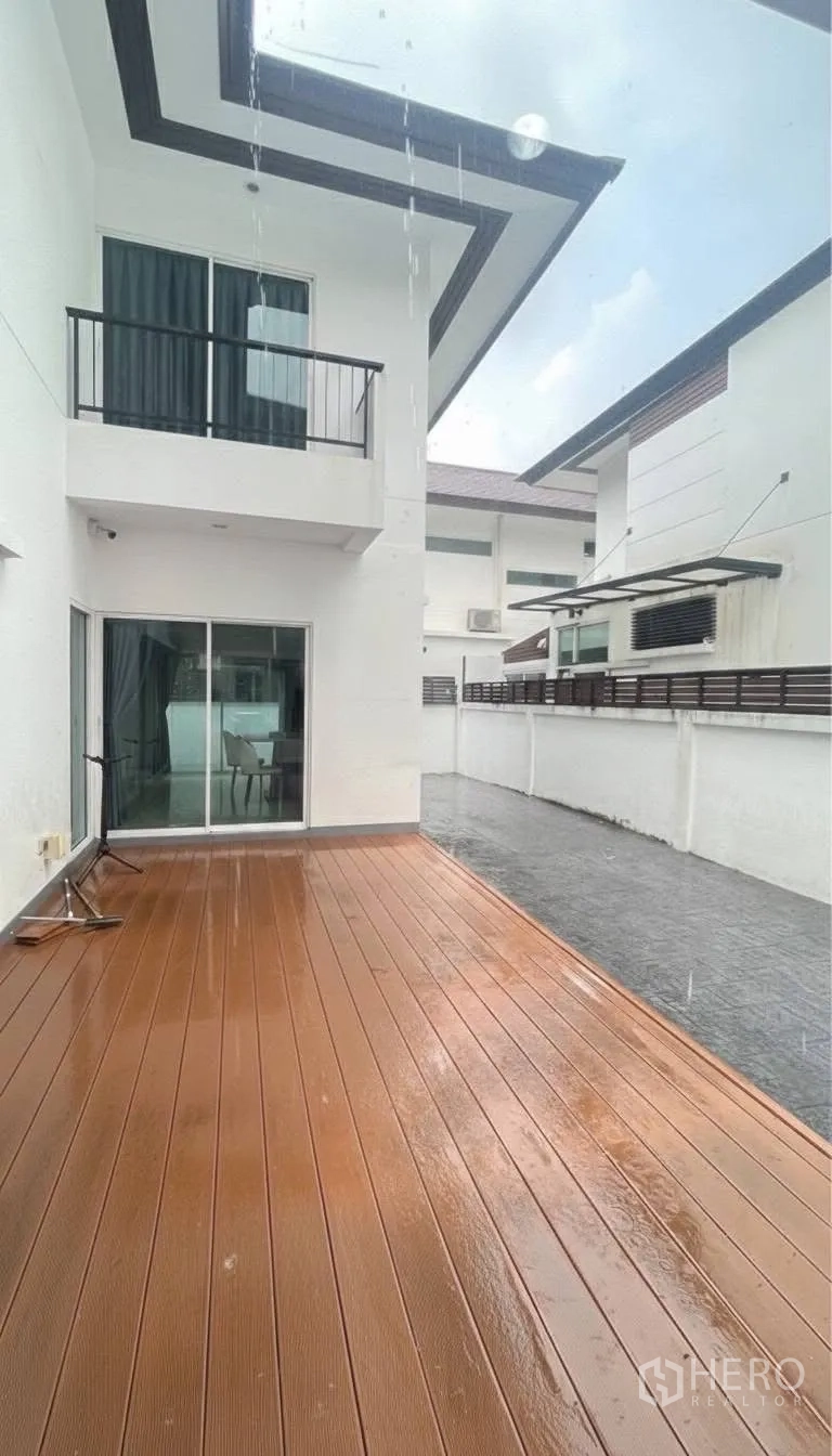 บ้านเดี่ยว for rent or sale in Saphan Sung, Bangkok - ลานด้านหลังปูพื้นไม้เทียมเชื่อมต่อประตูกระจกสู่ห้องนั่งเล่น.