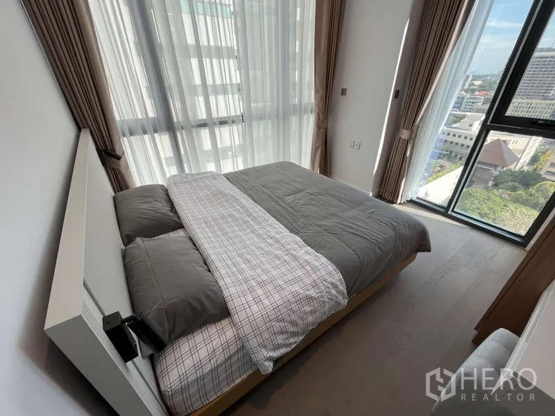 Condominium for rent or sale in Sathon, Bangkok - Corner bedroom with panoramic city view through tall windows.