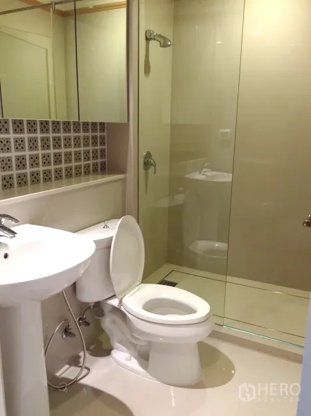公寓 出租在Khlong Toei, Bangkok - 带玻璃淋浴间的浴室，白色洁具与马赛克装饰