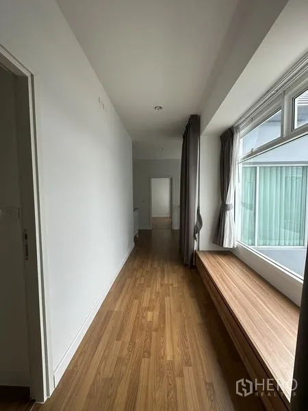 Detached House for sale in Lam Luk Ka, Pathum Thani - Upstairs hallway with a long window bench beside a large window.
