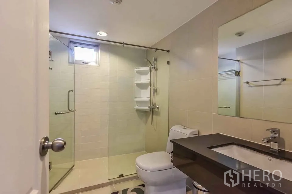 คอนโด for rent in Huai Khwang, Bangkok - ห้องน้ำทันสมัยพร้อมตู้กระจกอาบน้ำ เคาน์เตอร์อ่างล้างหน้า และโถสุขภัณฑ์
