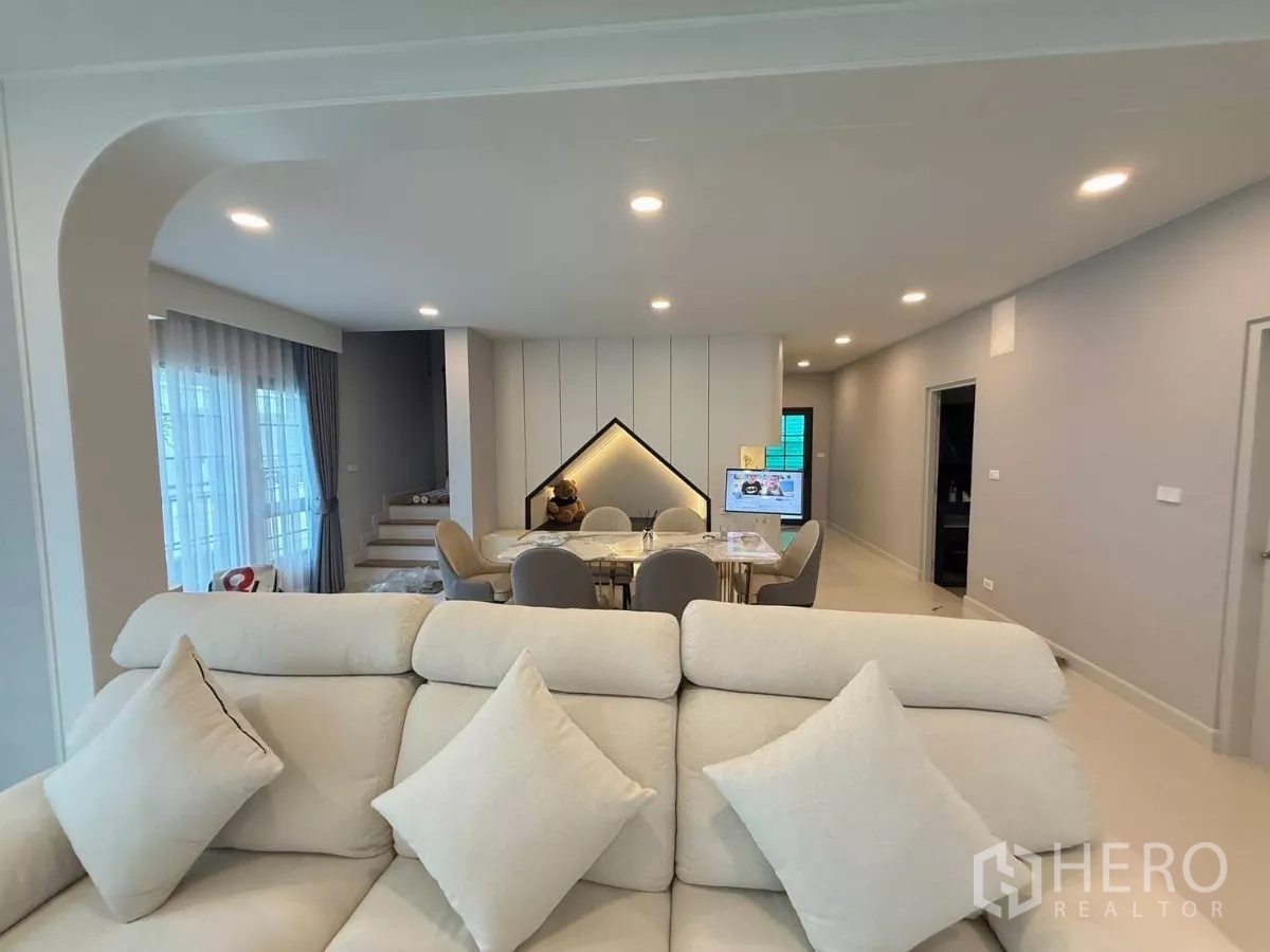 Detached House for rent in Bang Phli, Samut Prakan - Open living–dining space with arch details, recessed lighting, staircase and glass doors.