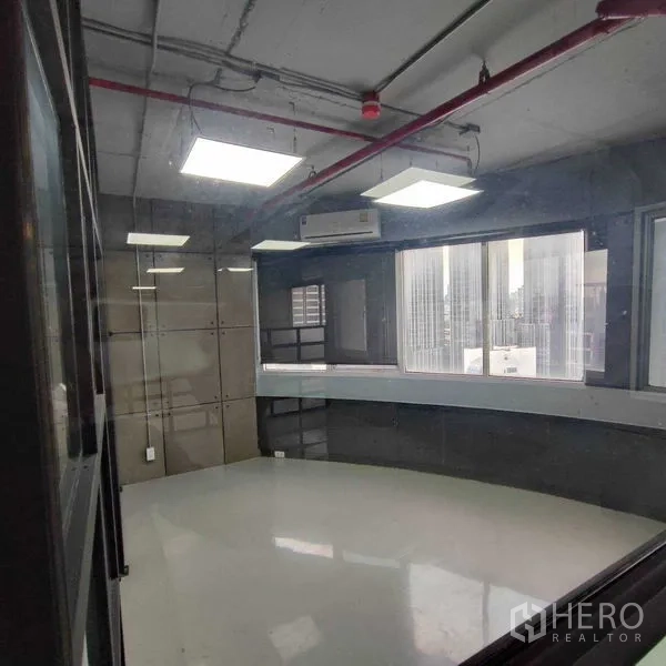 办公空间 出租在Watthana, Bangkok - 玻璃围合房间，明亮平板灯，弧形窗台与城市景致。