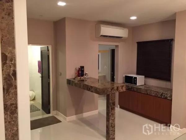 Detached House for rent or sale in Khlong Toei, Bangkok - Compact pantry with marble breakfast bar and counters, window blind, microwave and wall-mounted air conditioner.