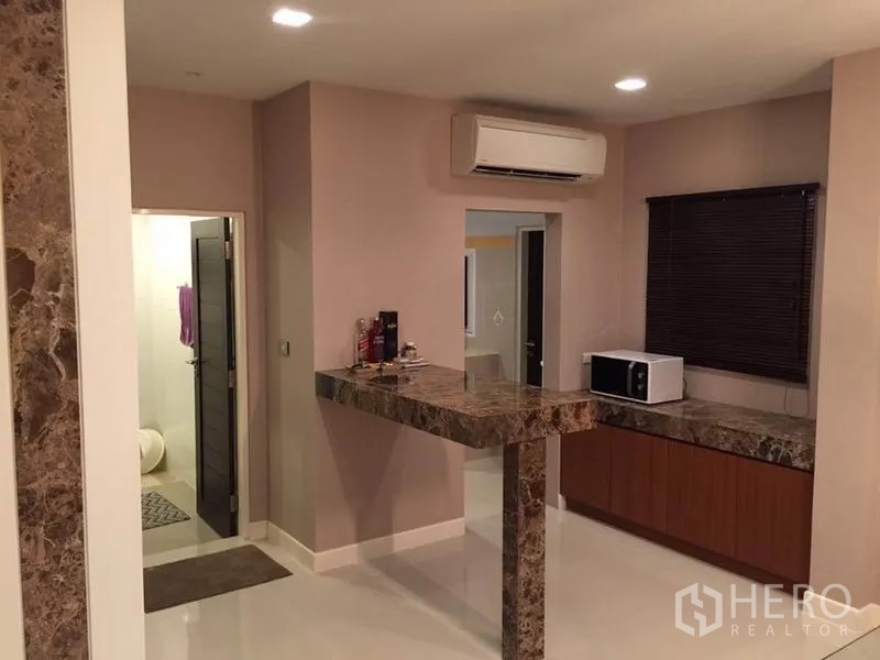 Detached House for rent or sale in Khlong Toei, Bangkok - Compact pantry with marble breakfast bar and counters, window blind, microwave and wall-mounted air conditioner.