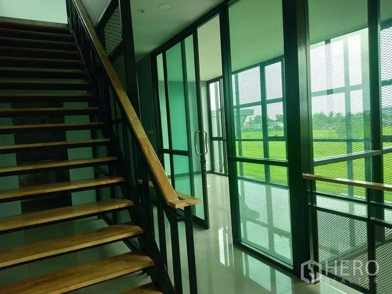 โรงงาน ให้เช่าหรือขาย - บันไดขึ้นห้องประชุมกระจก กั้นตาข่ายเหล็ก โทนกระจกสีเขียว