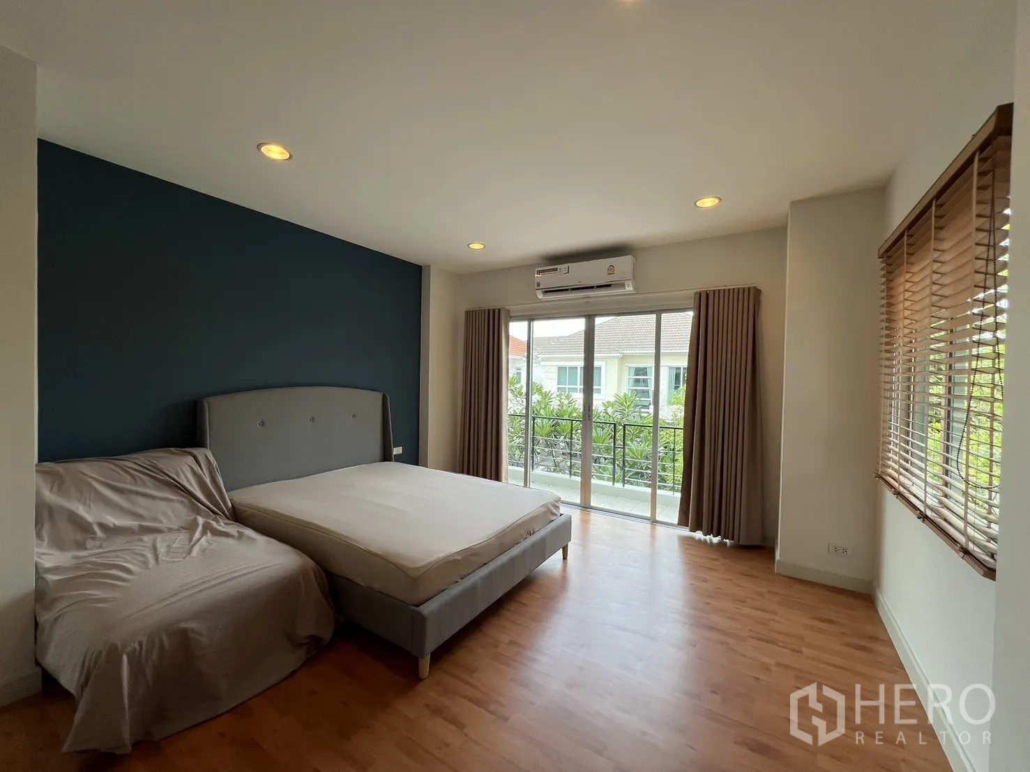 Detached House for rent in Saphan Sung, Bangkok - Master bedroom angle showing balcony access and corner windows.