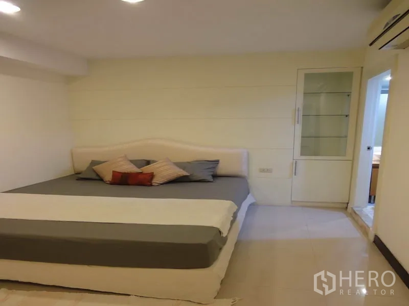 Condominium for rent in Watthana, Bangkok - Cozy bedroom with bed, side table and sliding door to ensuite.