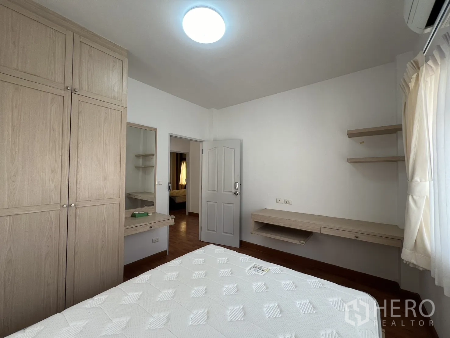 独立式住宅 出租在Bang Kapi, Bangkok - 卧室配浅木色衣柜、梳妆台与搁板。