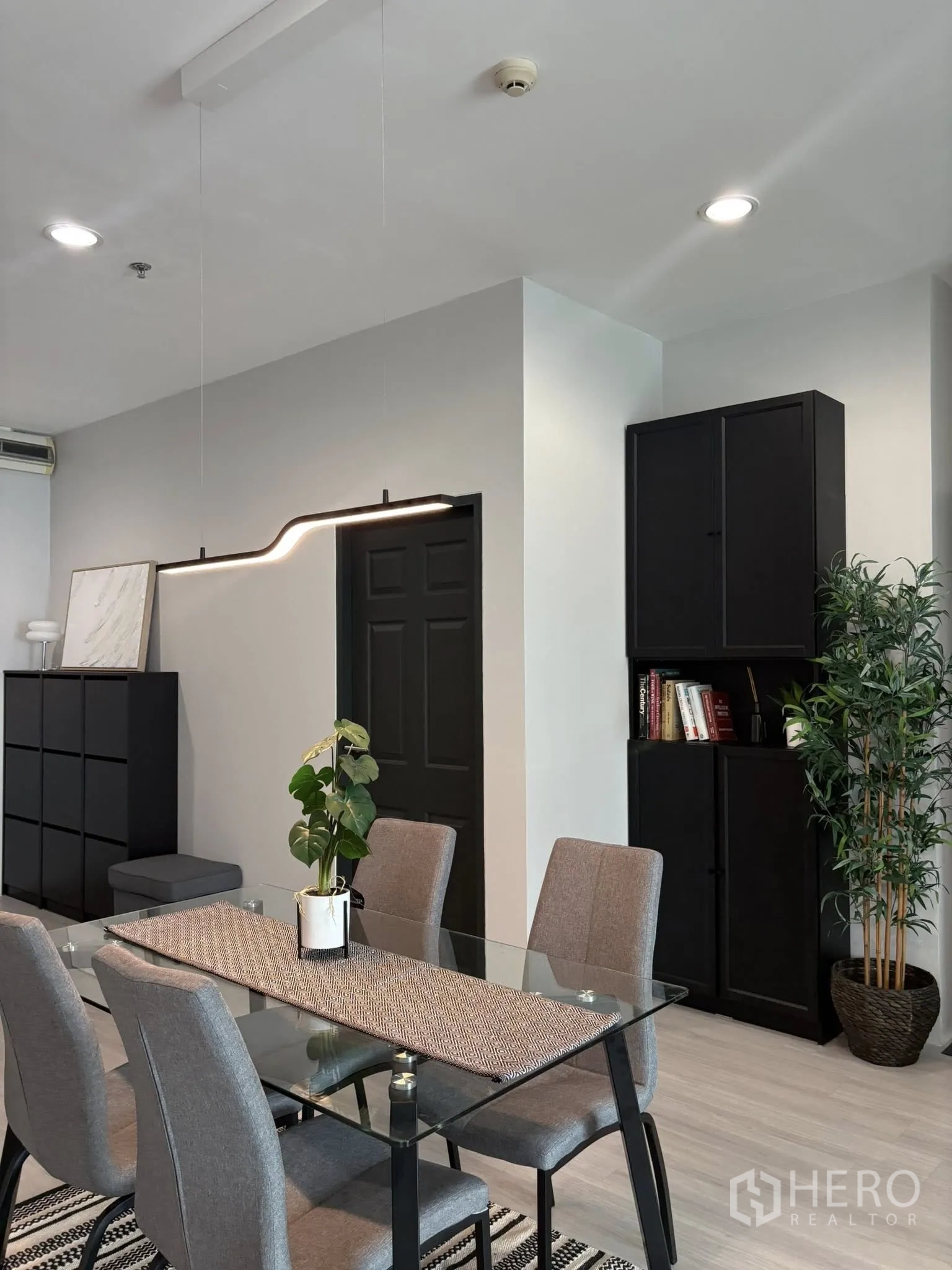 คอนโด for rent in Ratchathewi, Bangkok - ภาพระยะใกล้มุมรับประทานอาหาร โต๊ะกระจก โคมไฟแขวน และชั้นหนังสือ