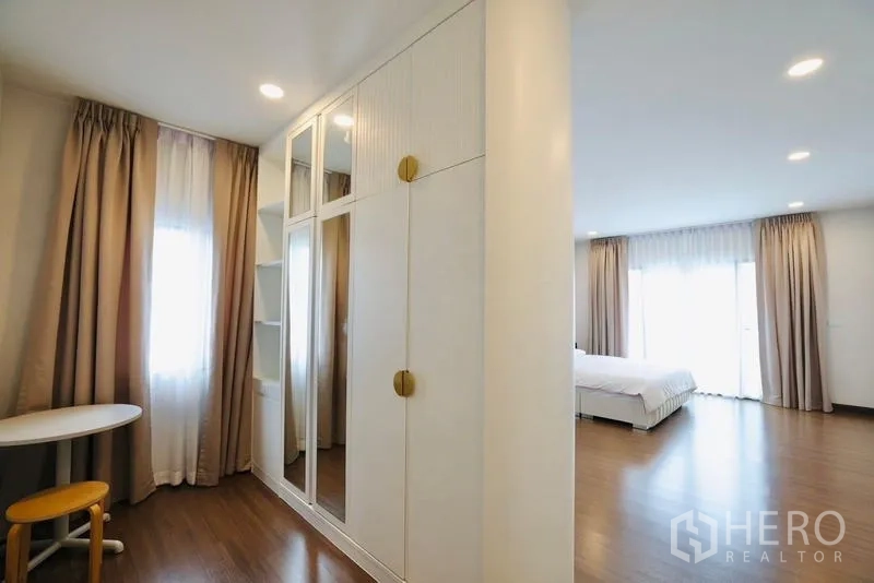 独立式住宅 出租在Bang Phli, Samut Prakan - 更衣角配白色嵌入式衣柜与穿衣镜，通往卧室。