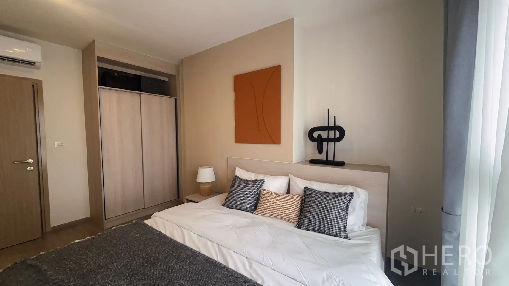公寓 for rent in Watthana, Bangkok - 卧室设大衣柜、抽象装饰画与灰色窗帘。