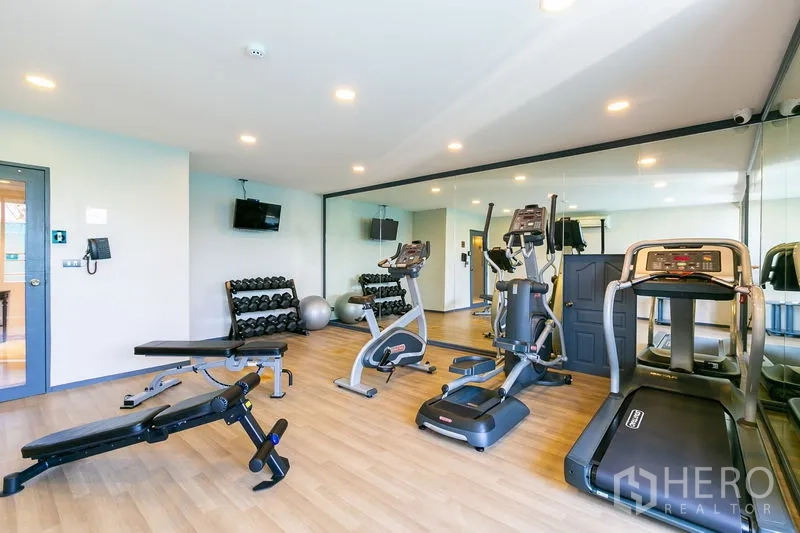 Apartment for rent in Watthana, Bangkok - Fitness room equipped with treadmills, weights, bench and full-length mirrors.
