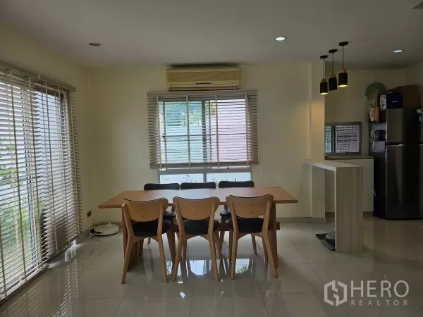 Detached House for rent in Khlong Toei, Bangkok - Cozy dining zone with wooden table for six, window blinds, pendant lights and wall-mounted air conditioner.