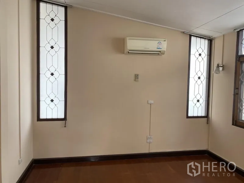 独立式住宅 出租在Khlong Toei, Bangkok - 紧凑房间，壁挂空调与两侧狭长装饰窗。
