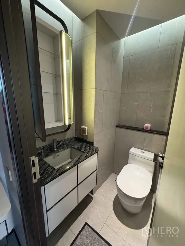 公寓 for rent in Watthana, Bangkok - 小型卫生间配发光镜柜、台盆与坐便器。
