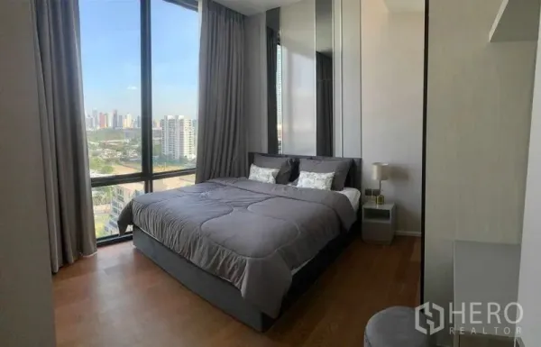 公寓 出租在Pathum Wan, Bangkok - 巴吞旺待租公寓的明亮卧室，巨幅窗户、城市天际线与木地板。