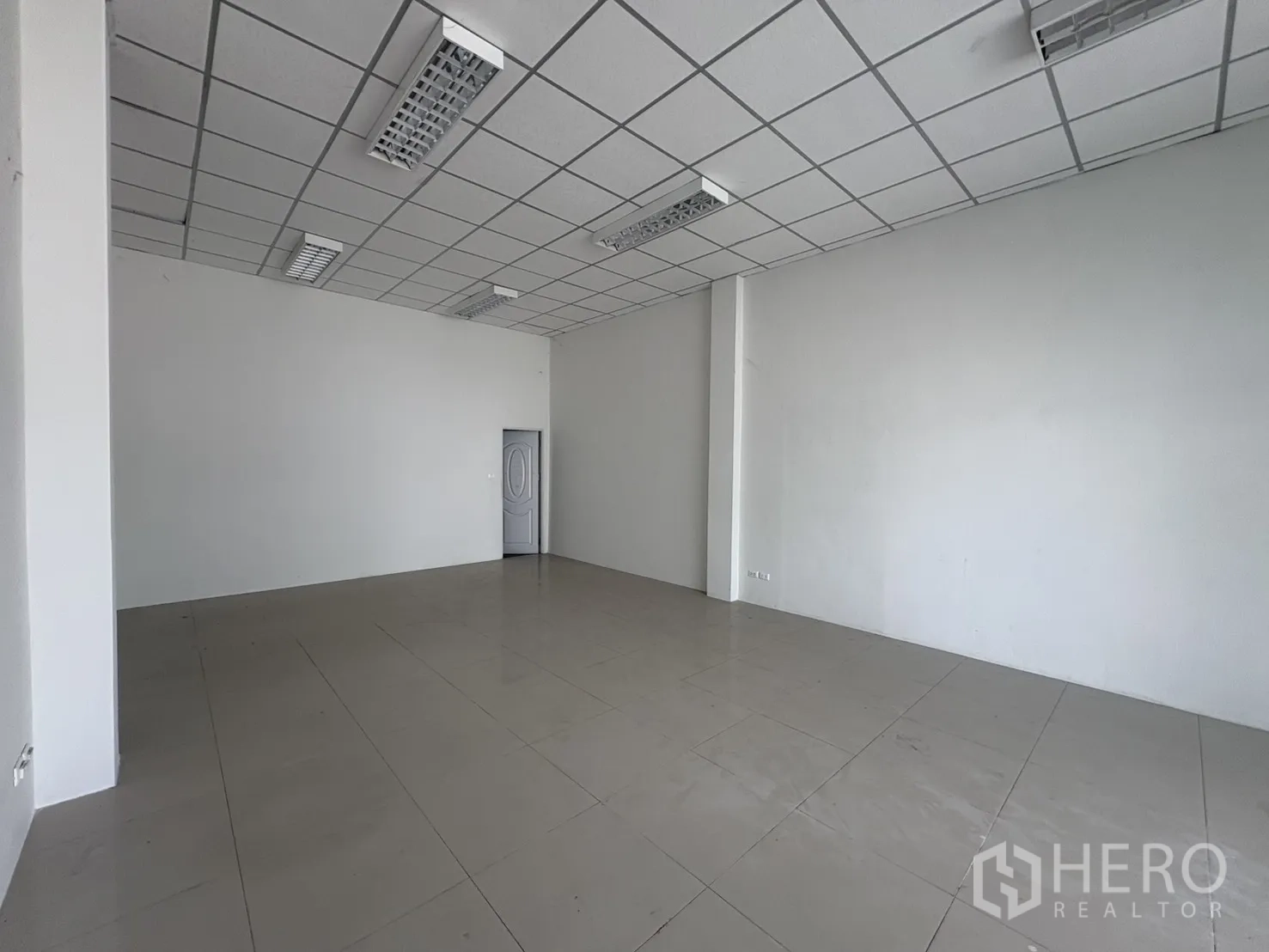 Factory for rent in Phra Samut Chedi, Samut Prakan - Clean tiled office room with grid ceiling and fluorescent lighting, ready for fit-out.
