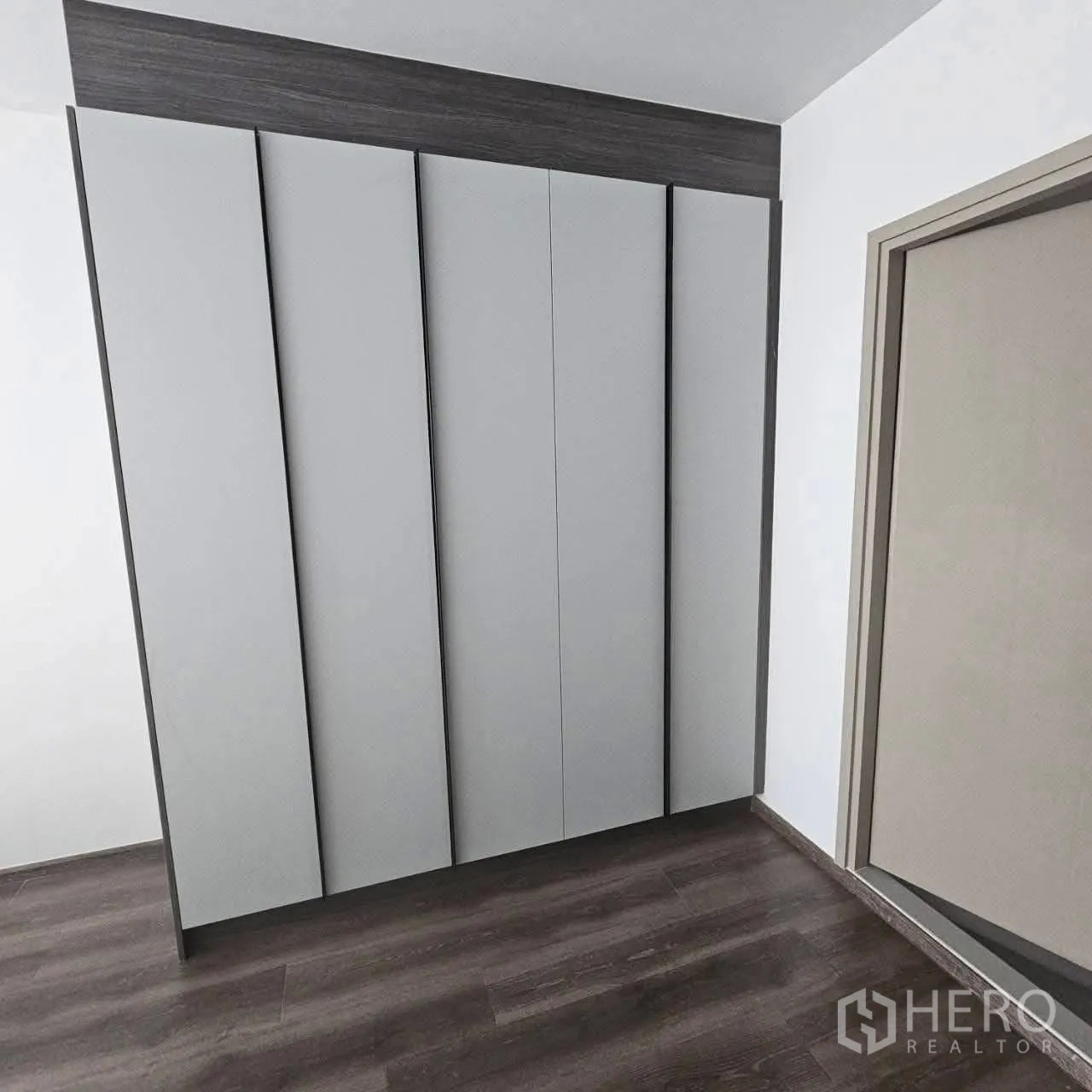 คอนโด for rent in Huai Khwang, Bangkok - ตู้เสื้อผ้าบิลท์อินบานสูงโทนเทาบนพื้นไม้สีเข้ม
