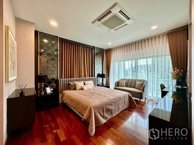 独立式住宅 出租在Bang Phli, Samut Prakan - 宽敞主卧，通阳台，设沙发与木地板。