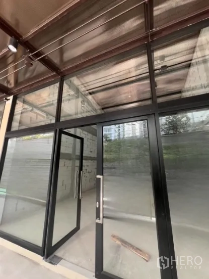 Retail Space for rent - Retail unit with floor-to-ceiling glass storefront and black metal frames, shell interior.