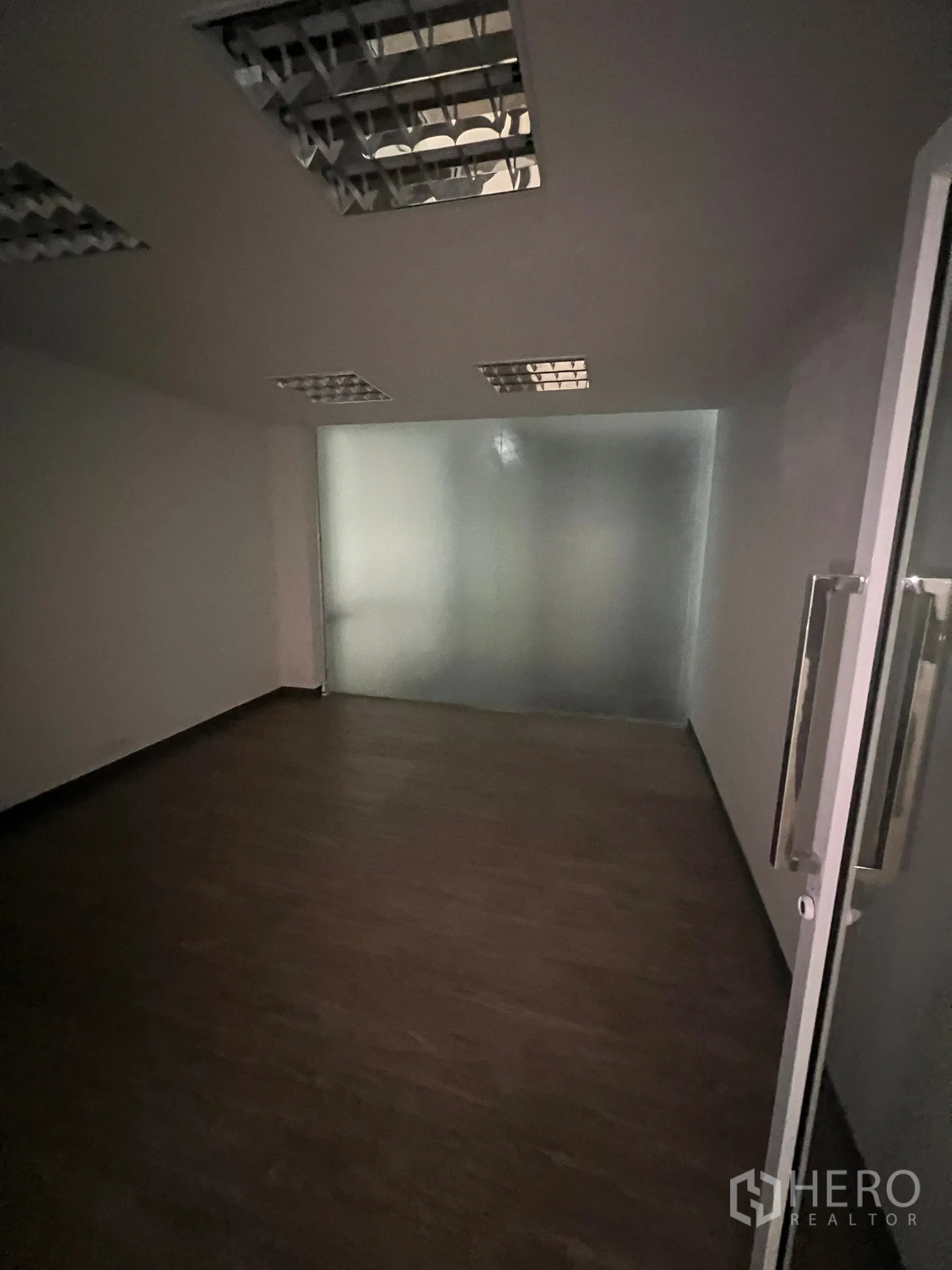 零售空间 出租在Watthana, Bangkok - 小型深色办公室，磨砂玻璃隔断与格栅灯。