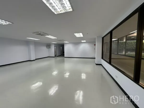 办公空间 出租 - 办公室转角视角，展示通透布局、临街窗面与洁白墙面。