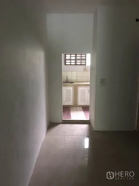 Shophouse for rent in Khlong Toei, Bangkok - Hallway leading to a pantry with natural light from ventilation blocks.