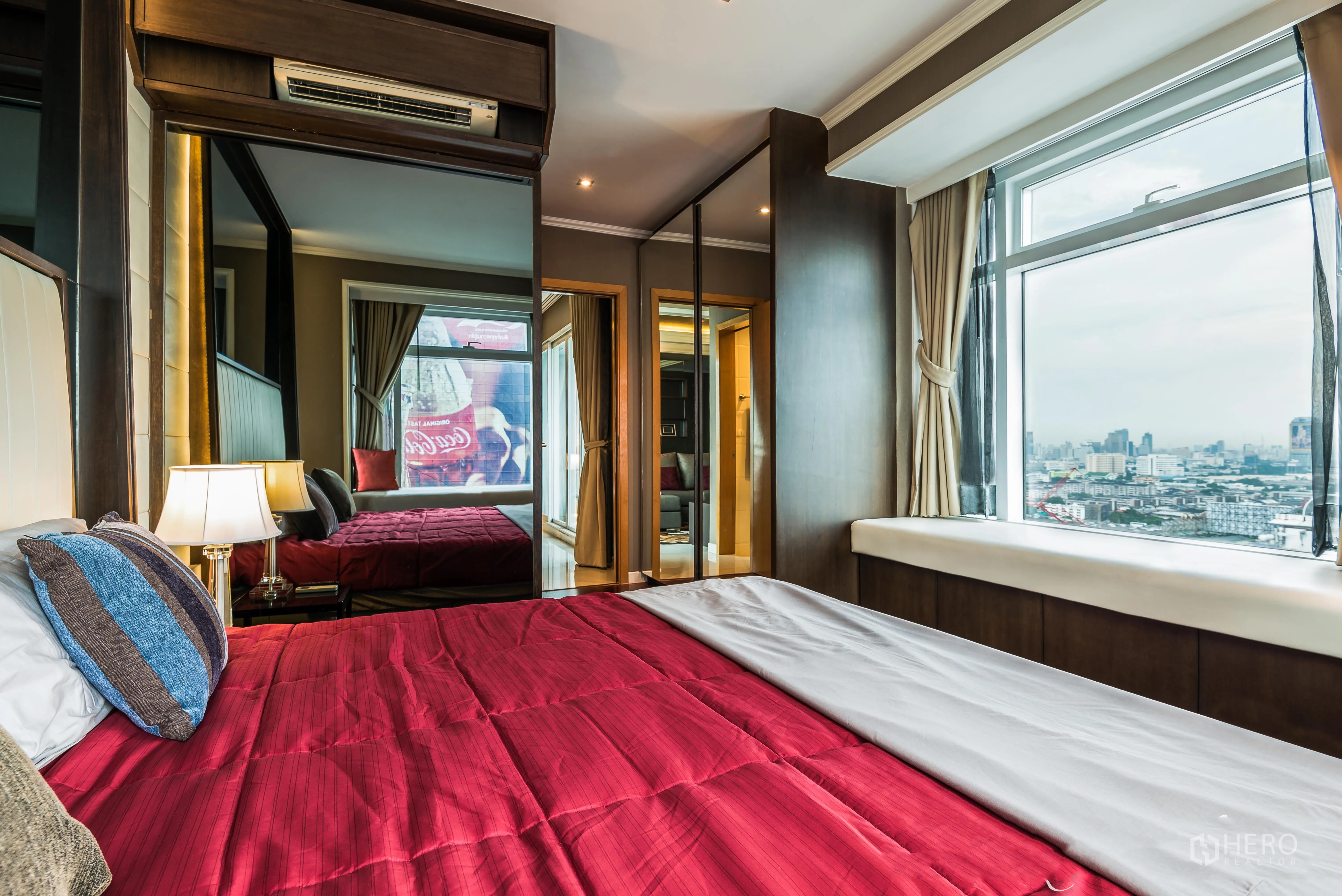 公寓 出租在Ratchathewi, Bangkok - 转角主卧，红色床品，镜面衣柜与大窗，城市景观开阔