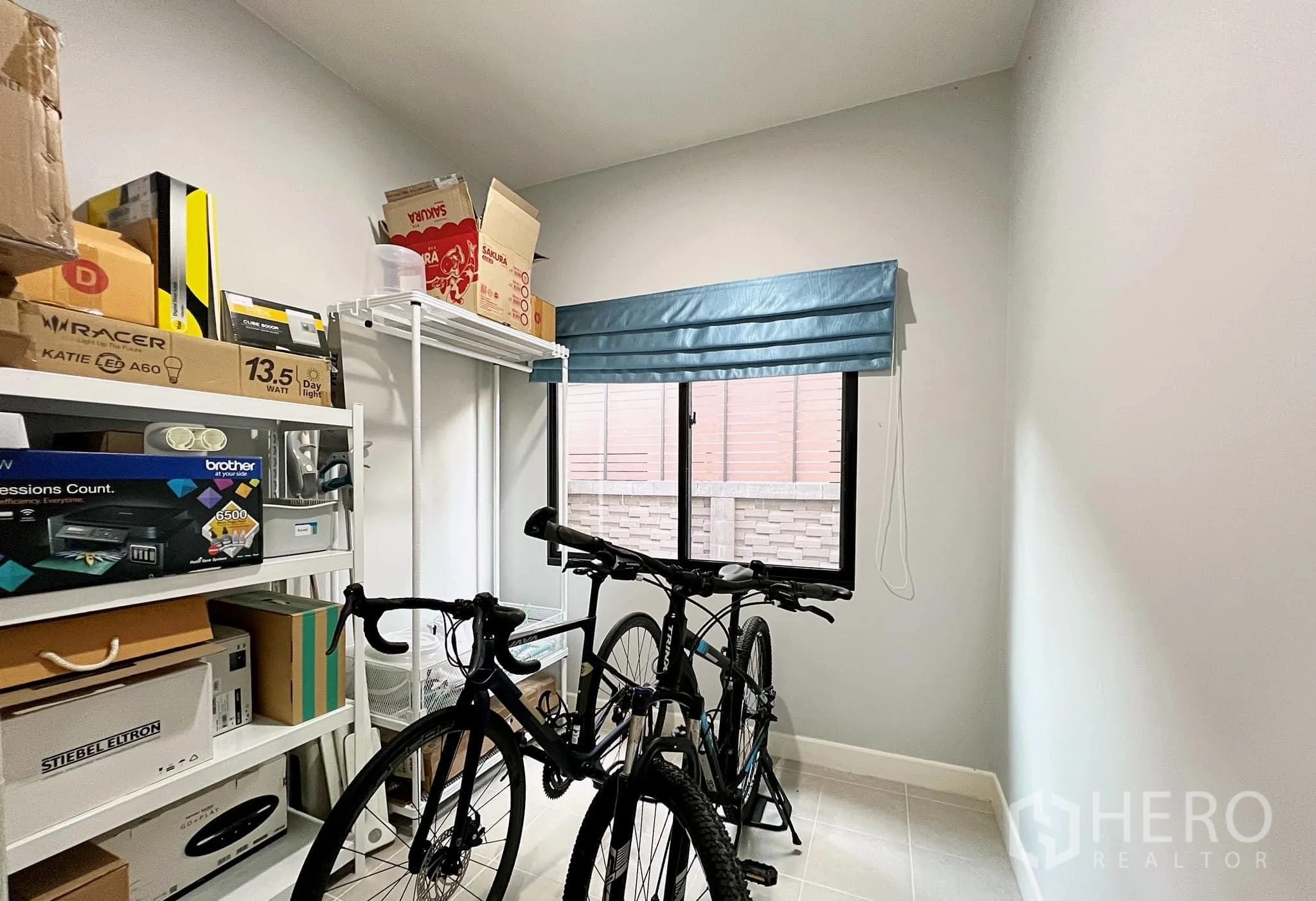 Detached House for rent or sale in Lam Luk Ka, Pathum Thani - Storage or hobby room with shelving and bicycles near a window.