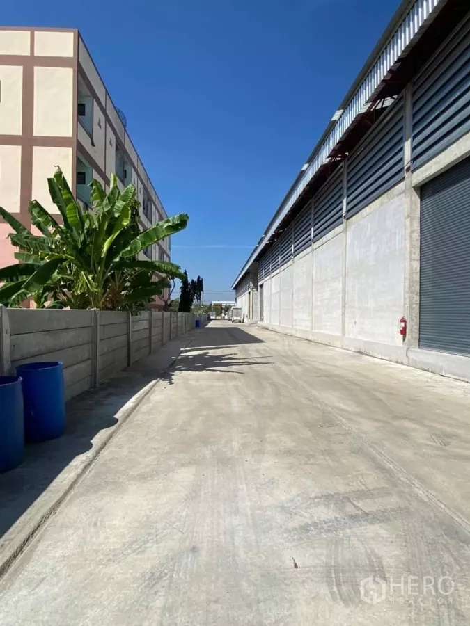 货栈 出租在Min Buri, Bangkok - 仓库外侧通道，卷帘门与宽阔车道，可供挂车出入。