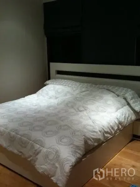 Condominium for rent or sale in Khlong Toei, Bangkok - Cozy bedroom with queen bed, white headboard, and soft lighting.