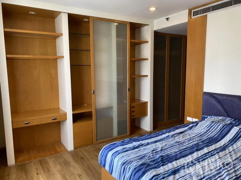 Condominium for rent or sale in Sathon, Bangkok - Second bedroom with built-in wardrobes, open shelving and a double bed.