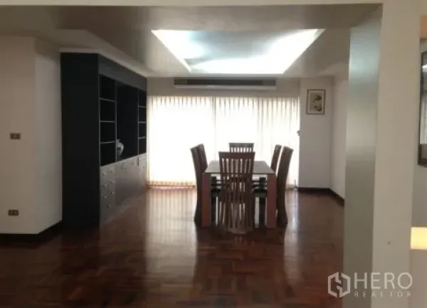 公寓 出租在Watthana, Bangkok - 宽敞餐区，拼花木地板、嵌入式天花、整面窗帘与内置柜。