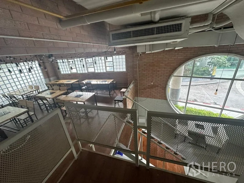 Retail Space for rent in Watthana, Bangkok - Brick-walled corner with round window and dining tables beside the stair.