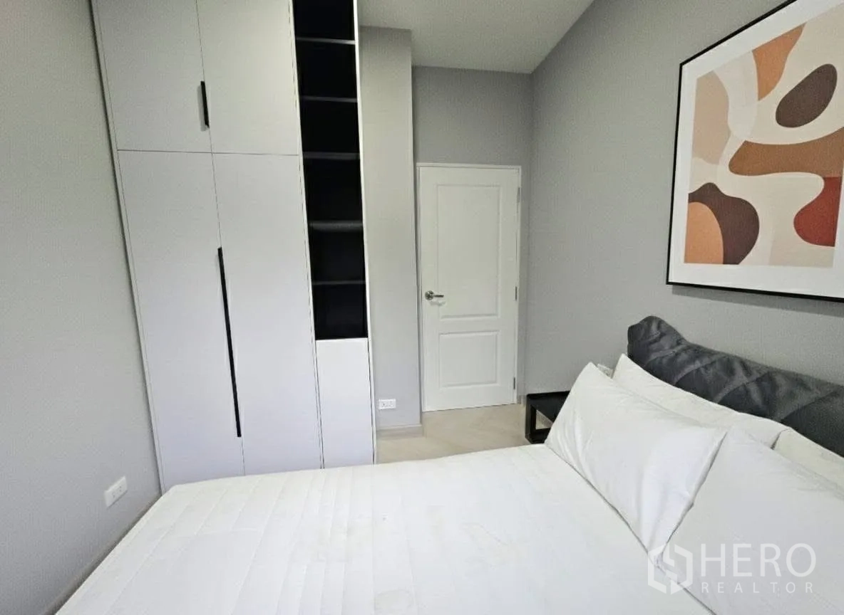 บ้าน for rent or sale in Bang Phli, Samut Prakan - ห้องนอนอบอุ่น ผ้าปูสีขาว งานศิลป์ติดผนัง และตู้เสื้อผ้าบิวท์อินสูงพร้อมชั้นโล่ง