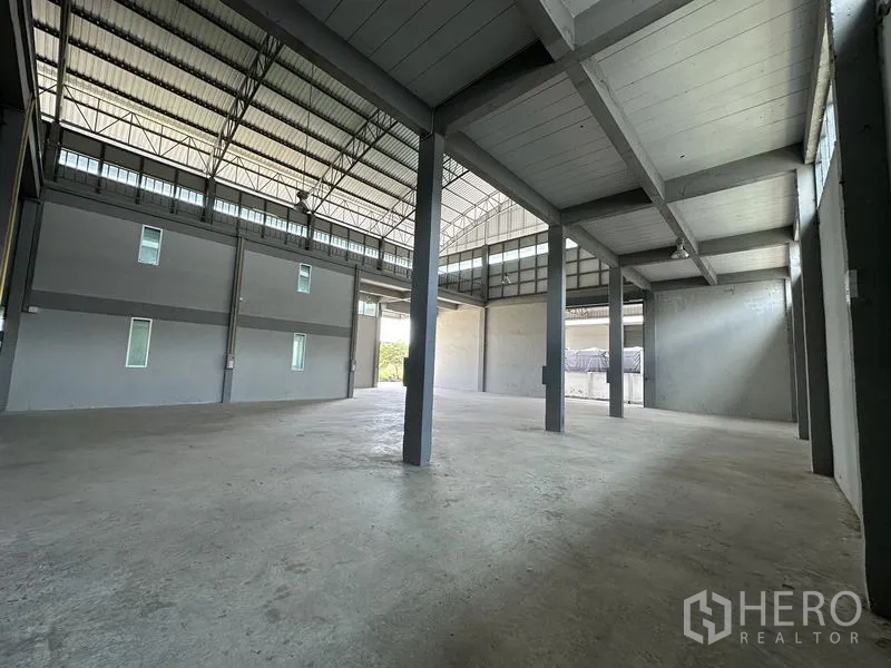 Factory for rent in Lam Luk Ka, Pathum Thani - Double-height production area with steel beams and partial mezzanine levels.