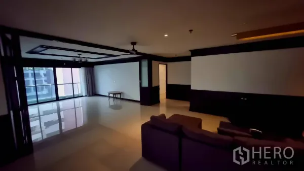Condominium for rent in Watthana, Bangkok - Corner living area opening to a balcony through full-height sliding doors.
