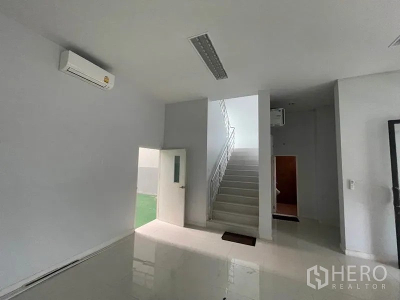 工厂 出租在Lam Luk Ka, Pathum Thani - 一层大堂与楼梯，旁有服务通道门