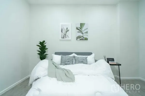 公寓 出售在Watthana, Bangkok - 极简卧室，白色床品、绿植与墙面装饰画