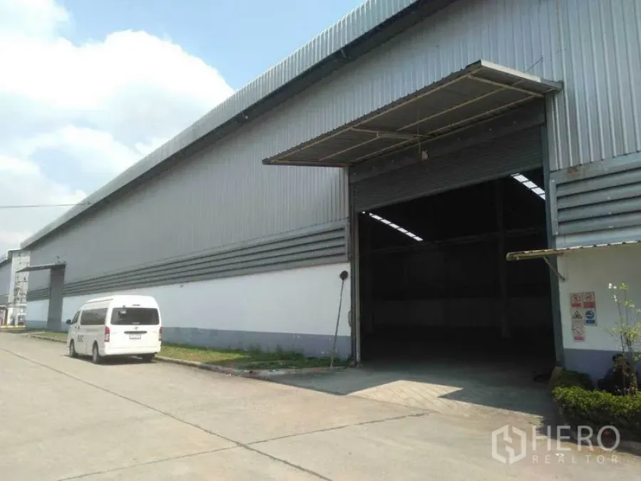 工厂 出租在Phra Nakhon Si Ayutthaya - 工厂外立面，大型卷闸入口及可通行卡车的车道。