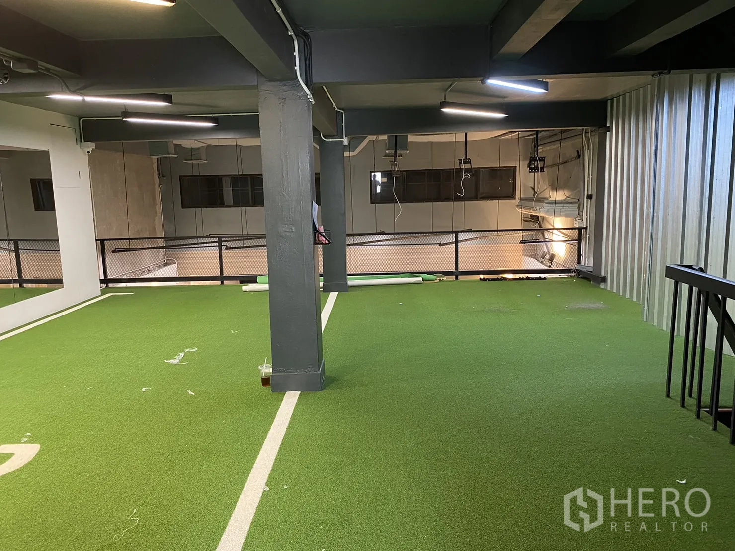 零售空间 出租在Phaya Thai, Bangkok - 夹层铺设人造草坪，LED照明与金属护栏，可俯瞰下层店面。