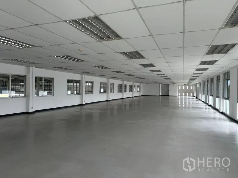 Factory for rent in Pathum Thani - Long open-plan office floor lined with windows on both sides.